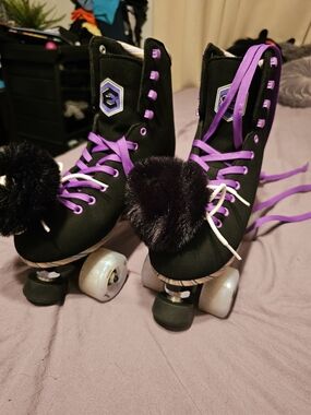 Purple-Laced Black Roller Skates with Pom Pom Accents